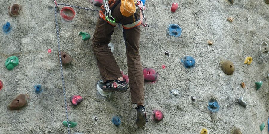 person climbing a concrete rock climbing wall