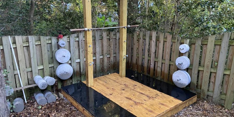Outdoor weightlifting platform with weight plates mounted on wall