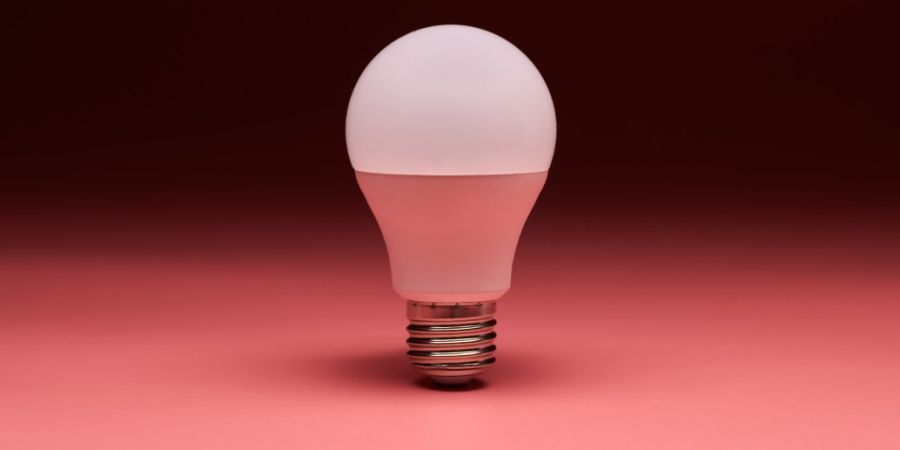 A no-heat light bulb on a red backdrop.