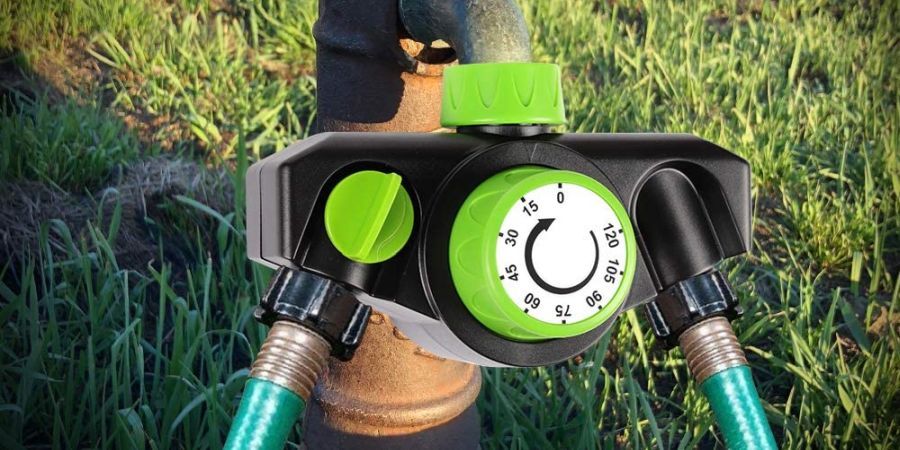 Analog mechanical watering timer by Kasonic attached to an outdoors faucet.