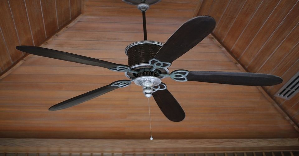 A ceiling fan with five blades and a single light bulb, brown in color.
