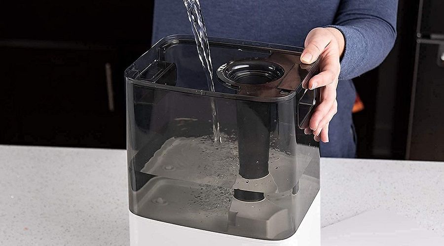 woman pouring water inside humidifier