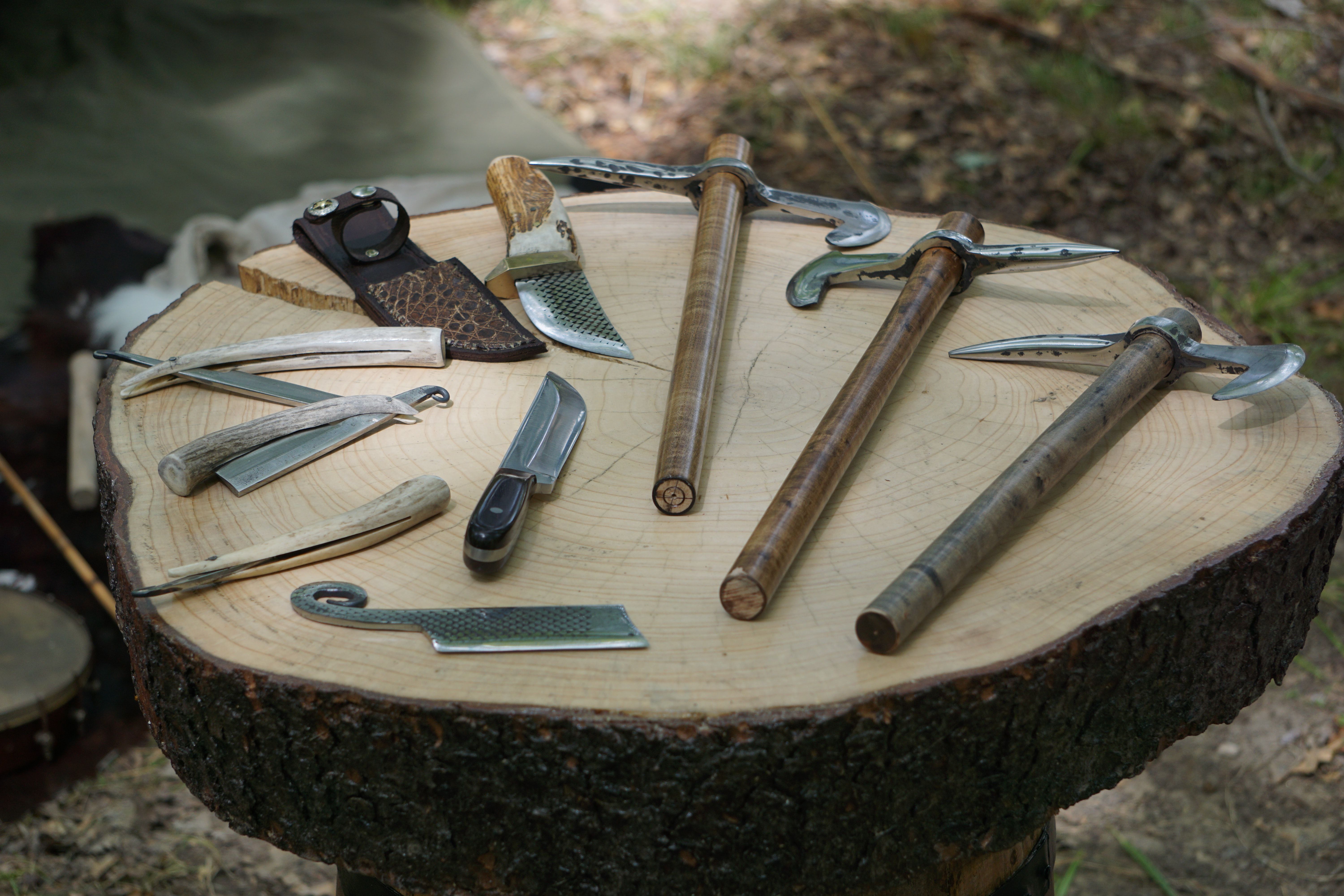 knives and axe lying down on a wood