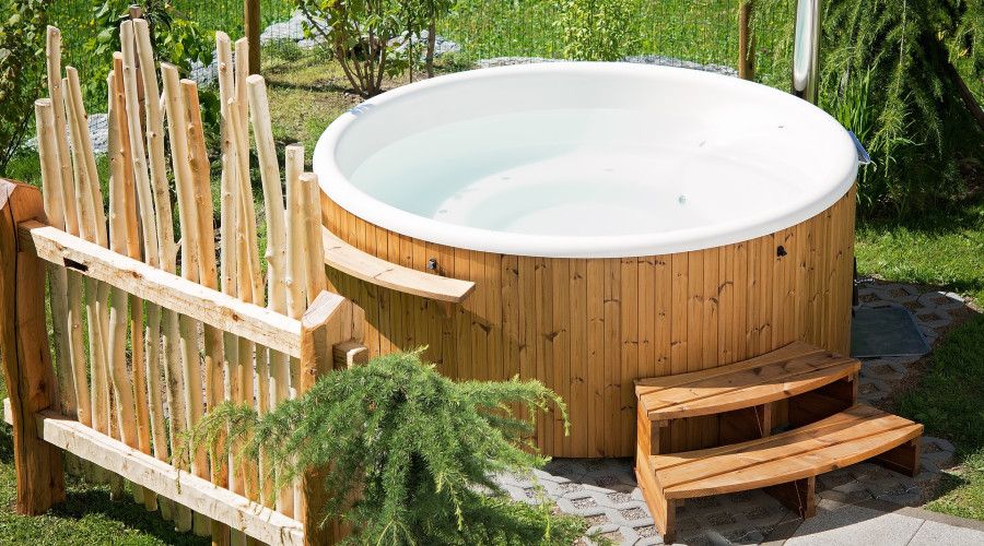 wooden hot tub with fence and steps