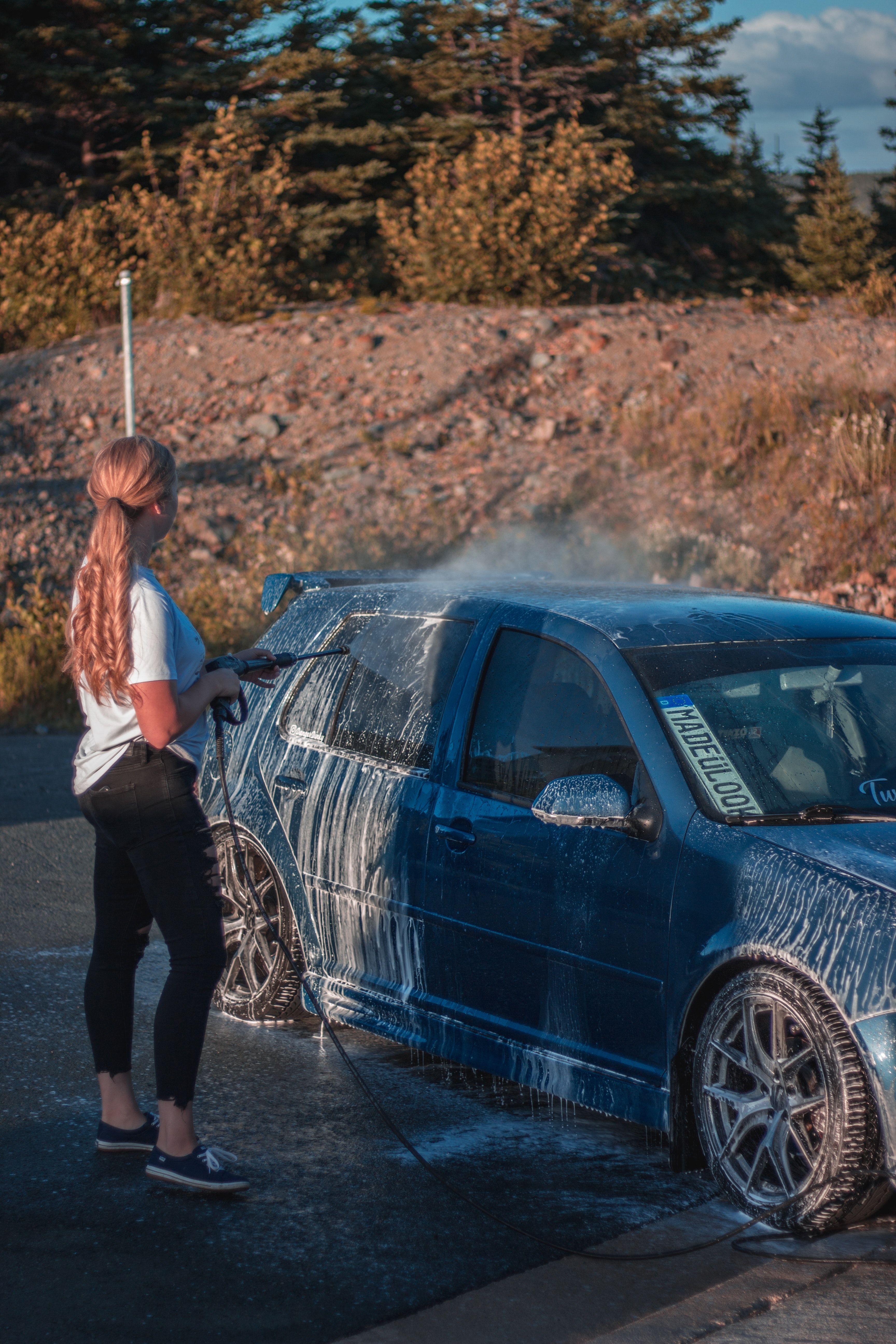 woman power washing car
