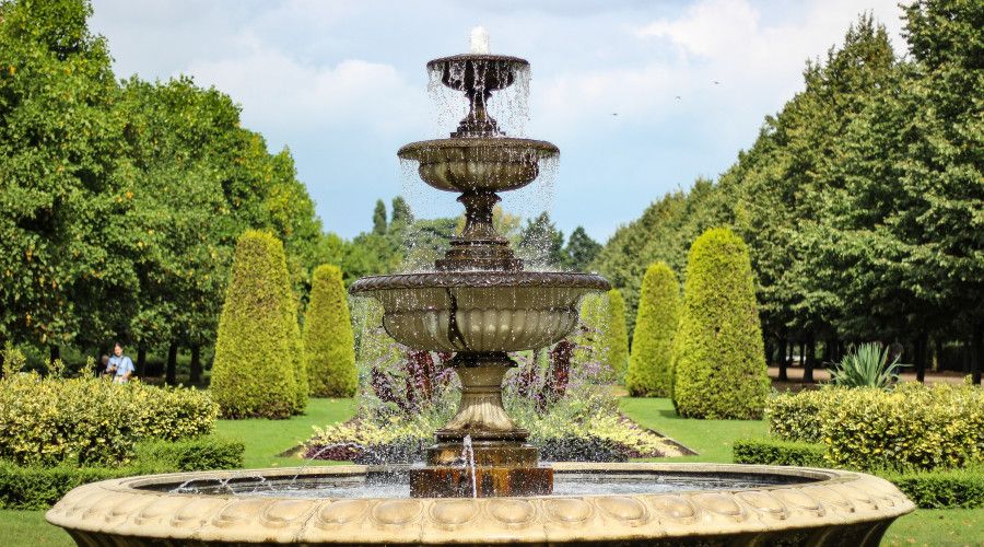 large water fountain with evergreens in background