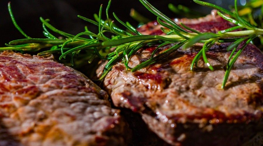 Grilled or broiled meat with herbs on top
