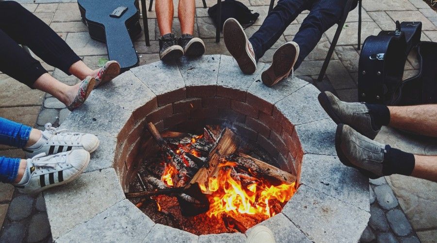 people's feet and guitar cases around the fire pit