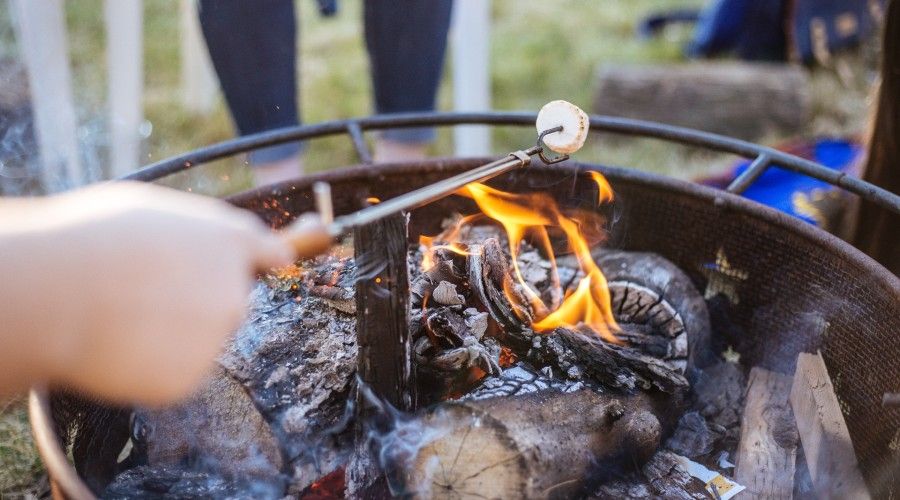 firpit table with someone roasting a marshmallow