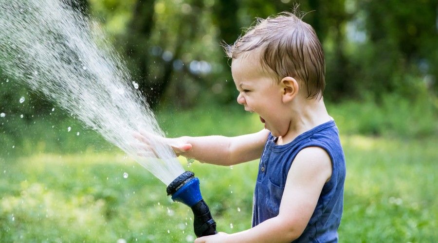 a child playing with a water hose