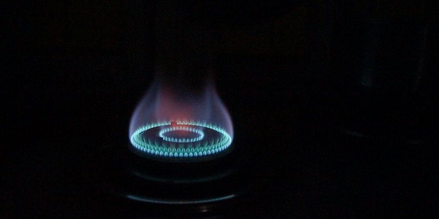 Gas cooker burning a blue flame in the dark 