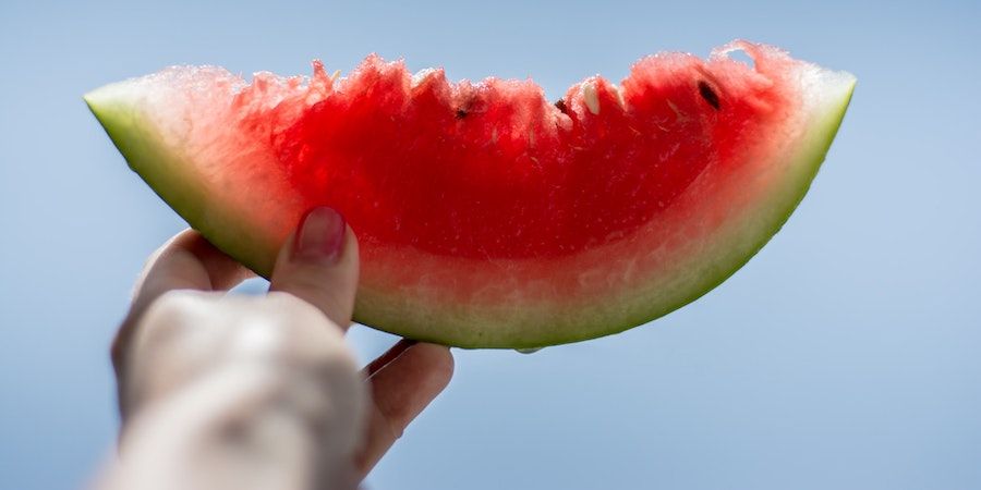 Hand holding a slice of watermelon