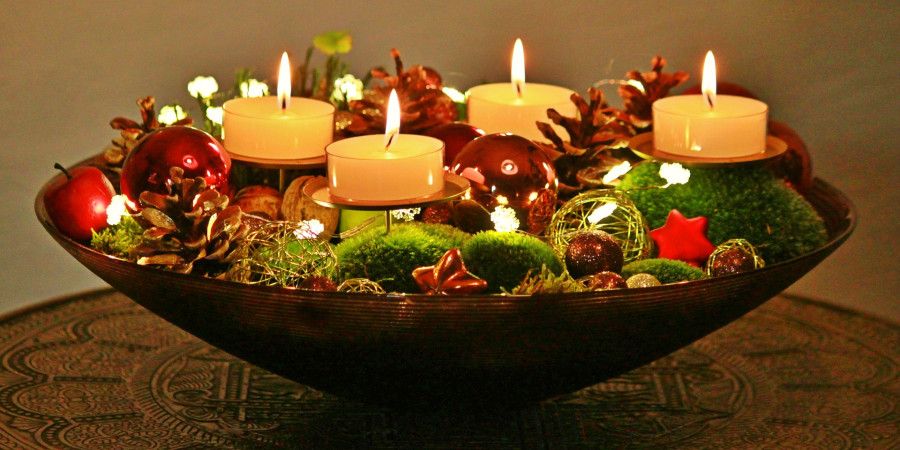 Bowl of lighted tea candles with Christmas decor filling the gaps