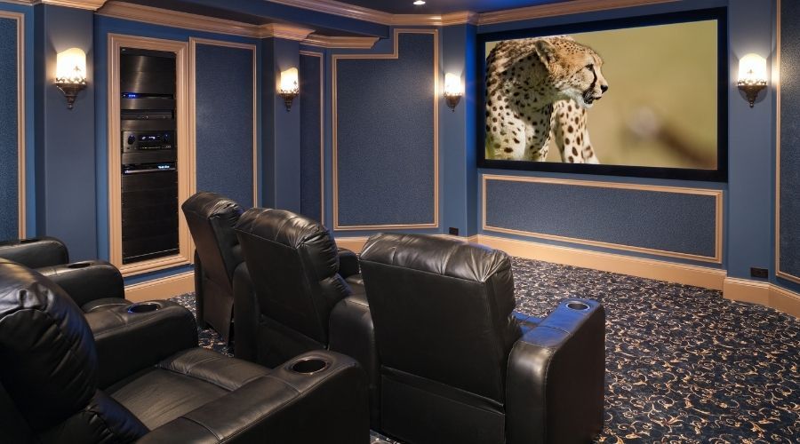 home movie theatre with screen and black leather chairs