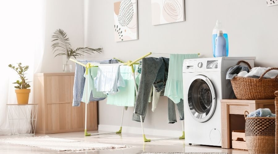washing machine and indoor clothing rack covered in clothing