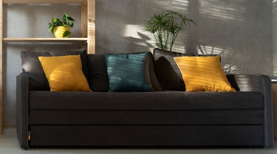 dark grey couch with colored throw pillows