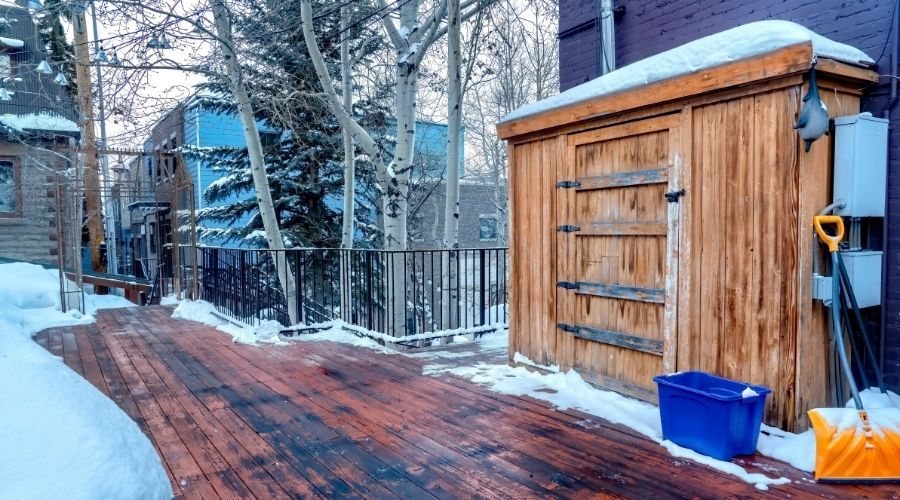 wooden storage cabinet on a deck in the snow