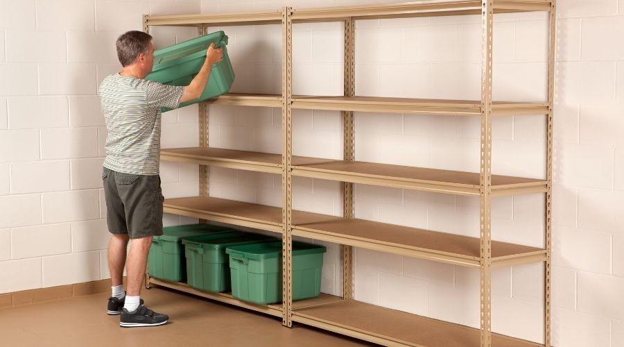 man placing plastic bin on a shelf