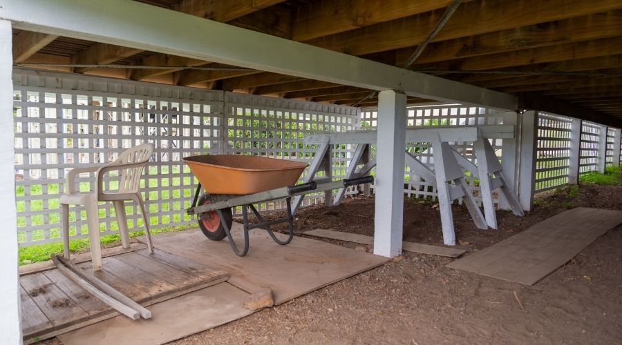 wheelbarrow and patio furniture under a deck