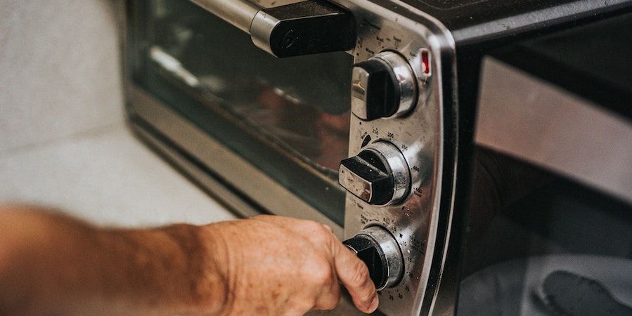 Person adjusting oven dials 