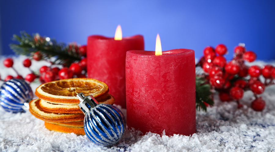 Christmas candles with dry oranges, baubles and red berries