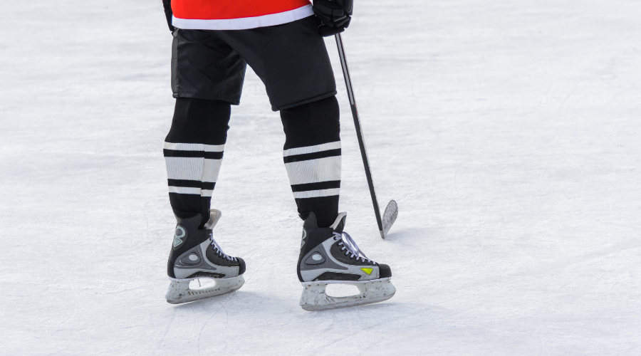 Hockey Player with a Stick Standing on Ice
