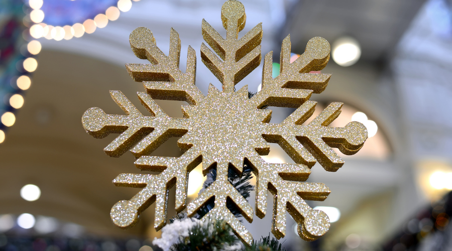Large golden snowflake on top of a Christmas tree
