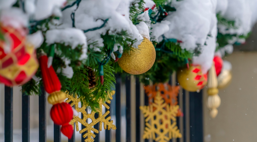 Festive snow covered garland on porch railing