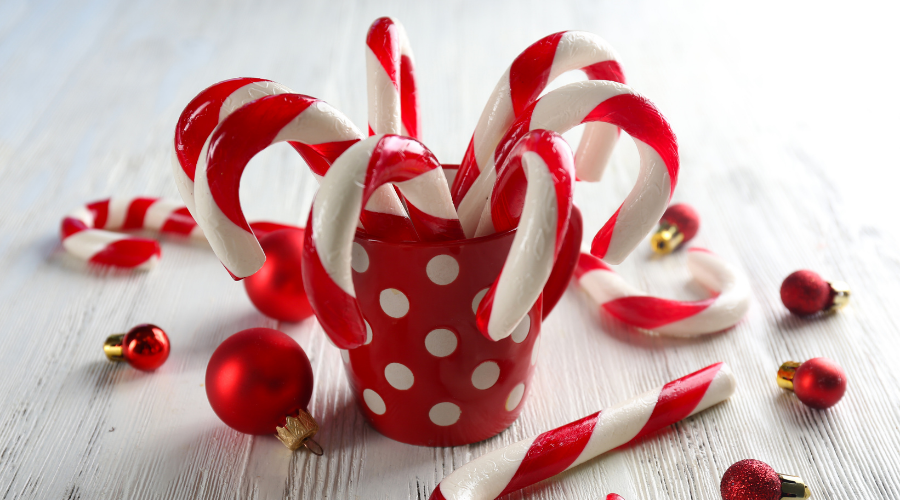 Christmas Candy Canes in Cup on Wooden Table
