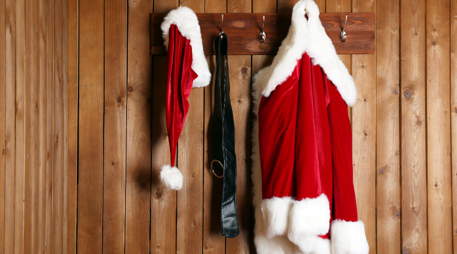 Santa Costume Hanging on Wooden Wall Background