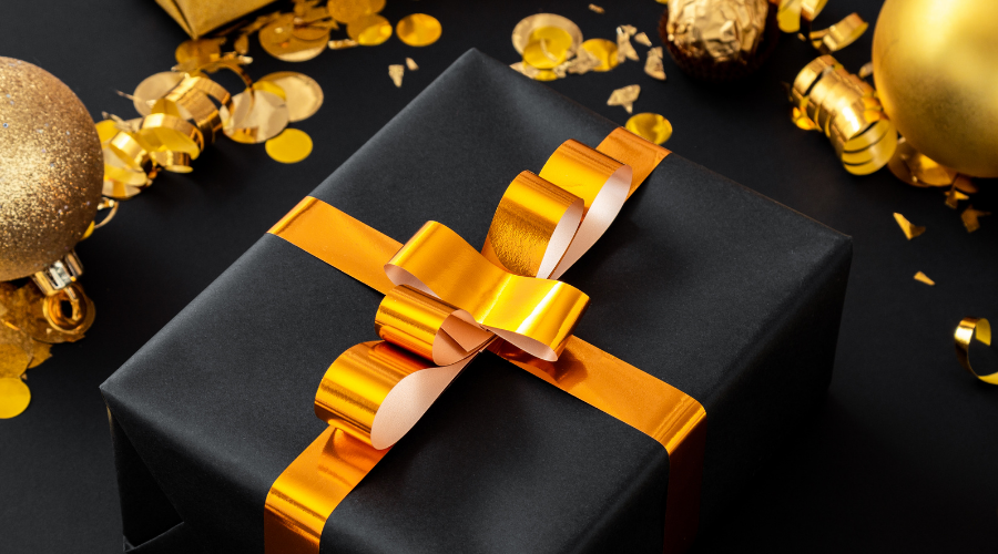 Black christmas gift with gold ribbon bow
