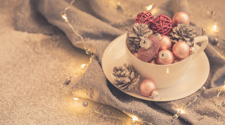 Pink christmas balls and natural cone in the white tea set on grey