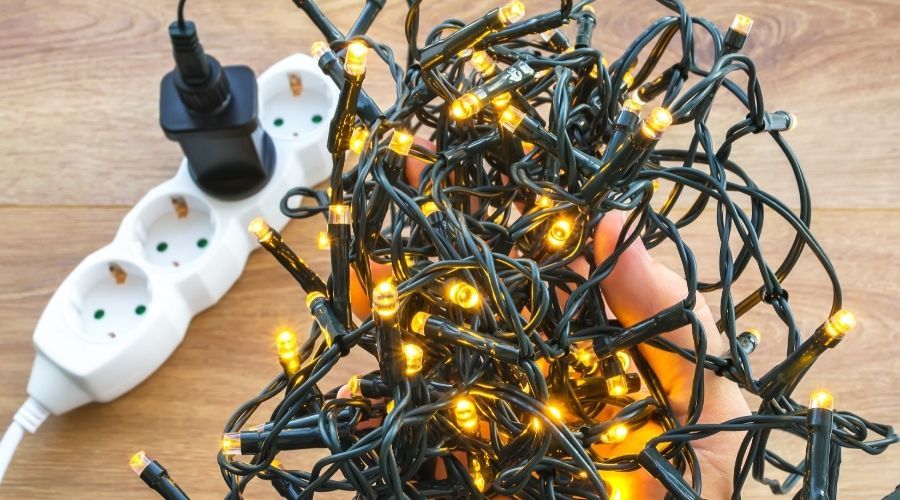 white Christmas lights plugged into white extension cord