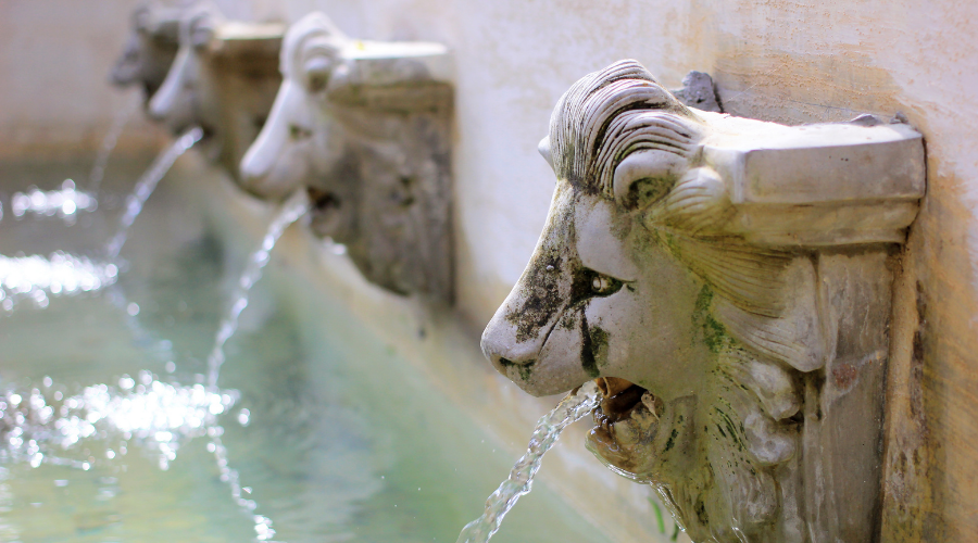 Water flow from lion statue on wall