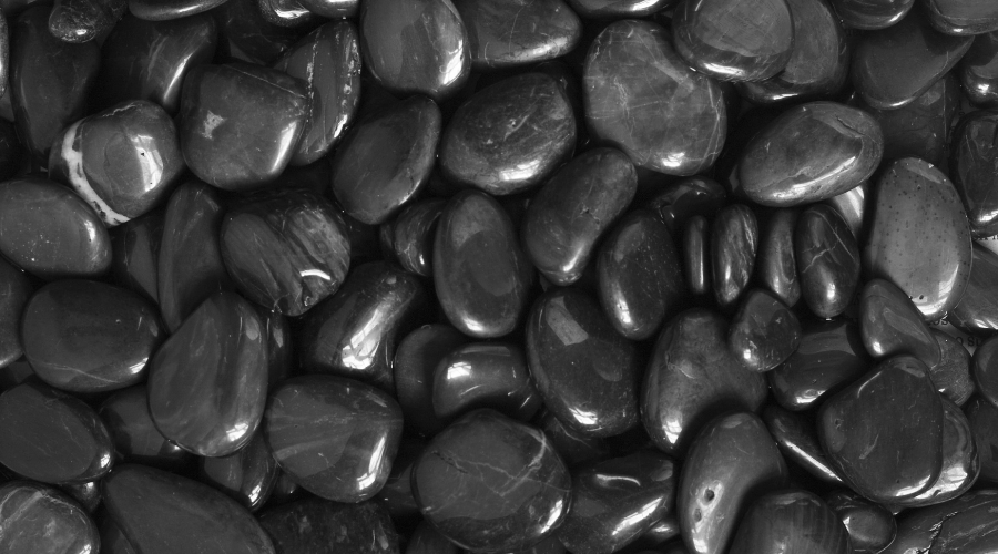 Closeup BW Smooth Polished Black Pebble Rocks Background