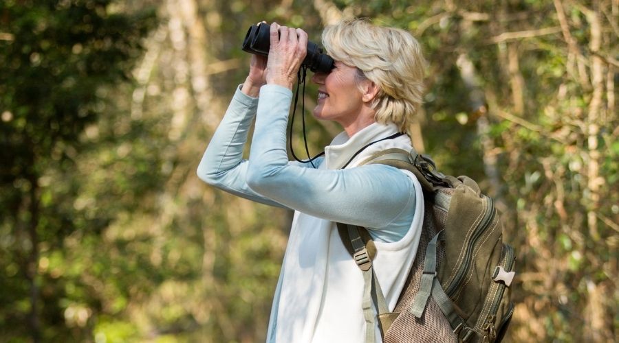 a woman on a hike looking through binoculars