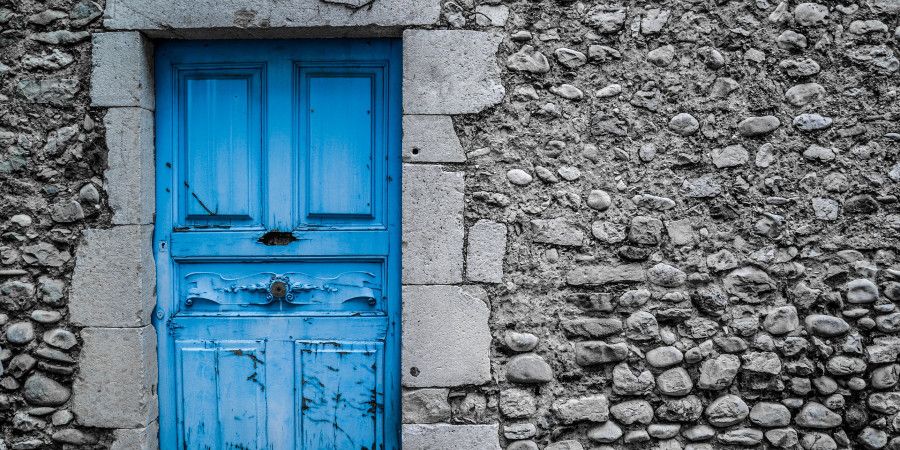 old blue wooden door in stone wall