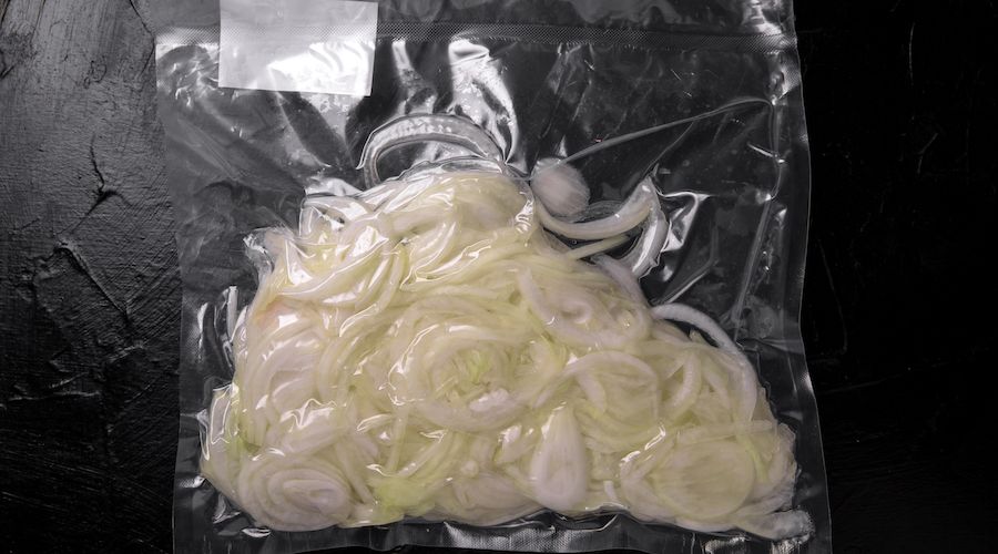 Prepack Vegetables Ingredients. Fresh raw whole onion, peeled, sliced, ready to cooking package blowing (bagginess) in vacuum packaged.
