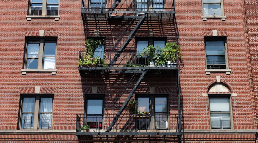 Fire Escapes with Potted Plants on an Old Brick Apartment Building in Astoria Queens New York