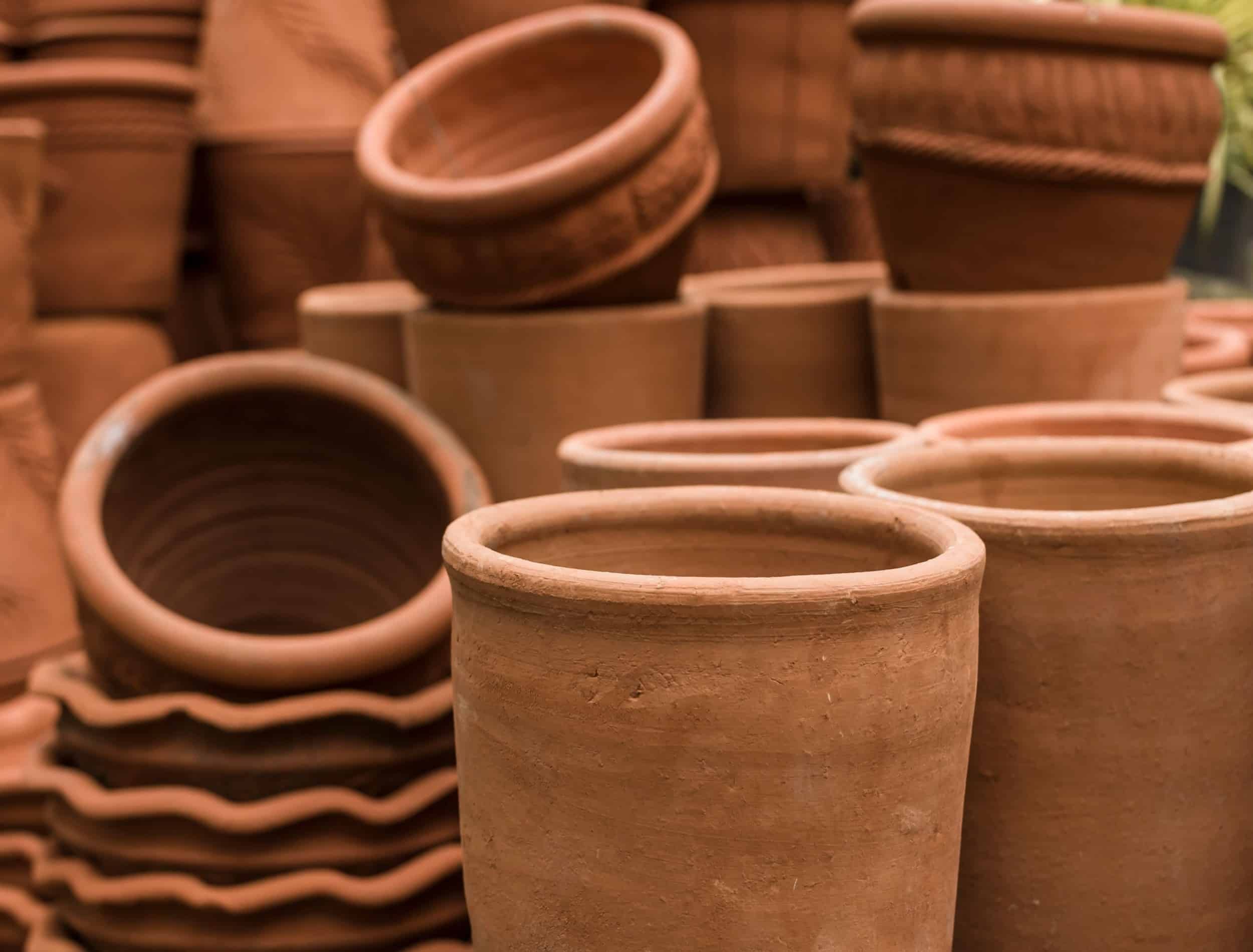 Stacks of various terracotta pots for plants for sale at a garden store.