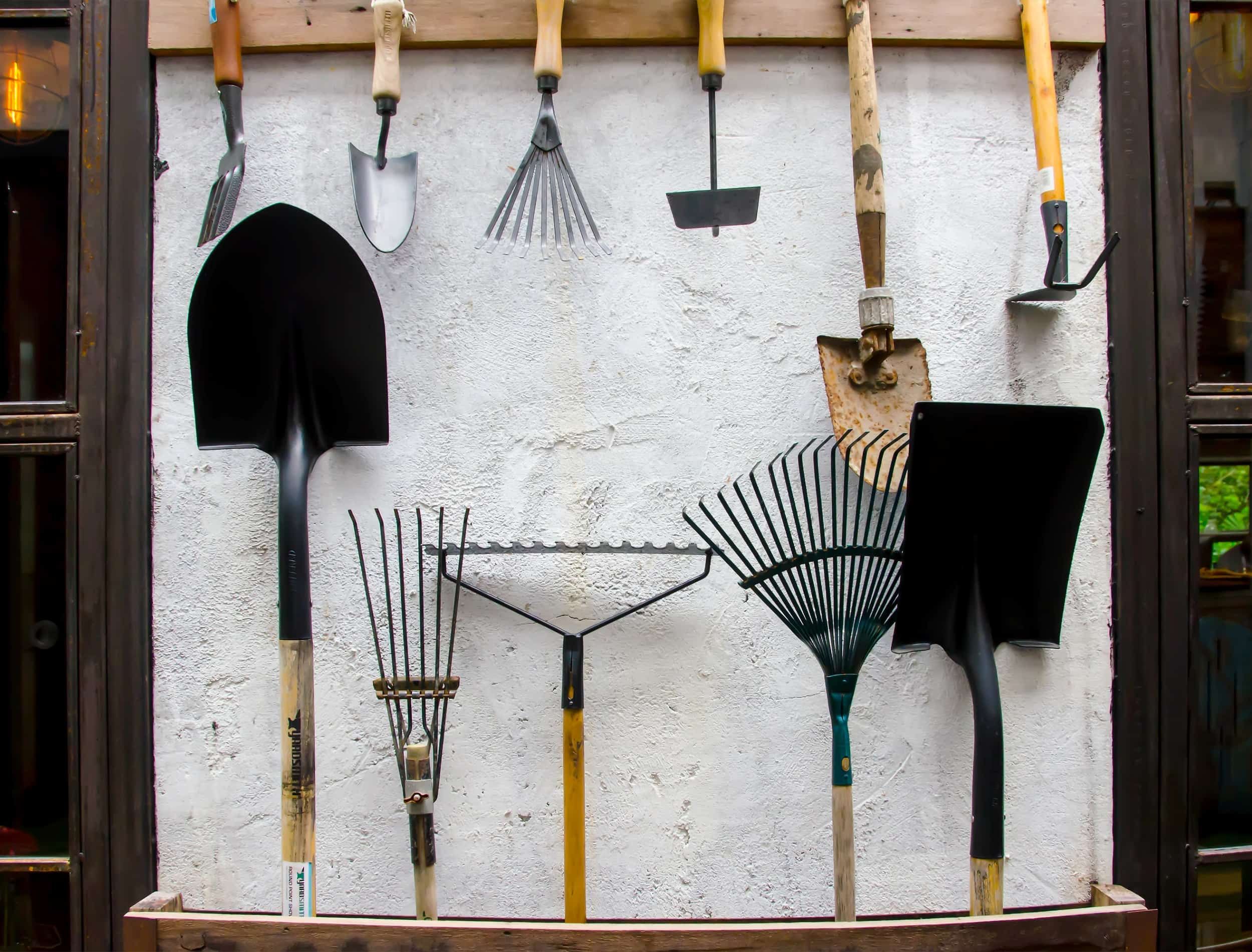 gardening tools on cement wall - tool concept.
