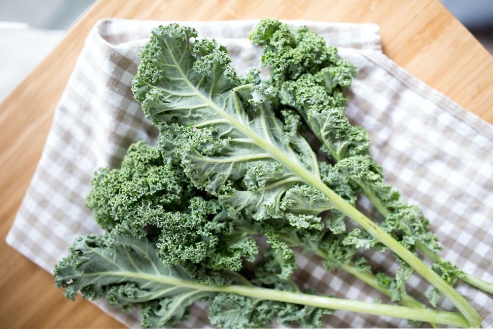 Kale leaves drying on a towel on a cutting board