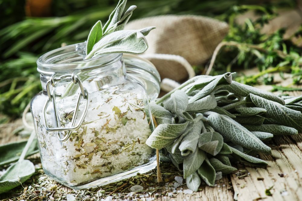Sea salt, milled with sage in a glass jar, fresh herbs