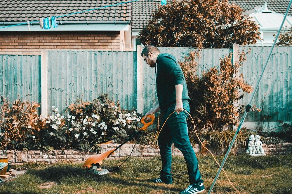 Man cutting backyard grass