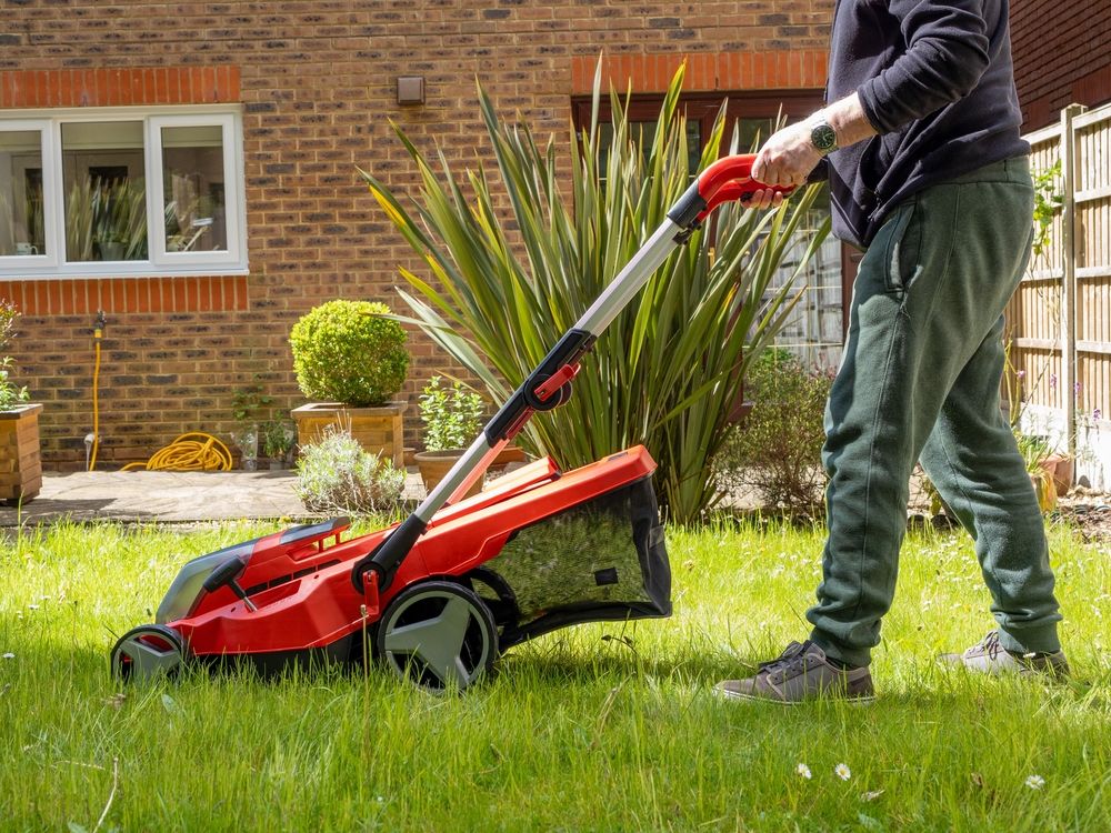 Man mowing with a cordless lawnmower