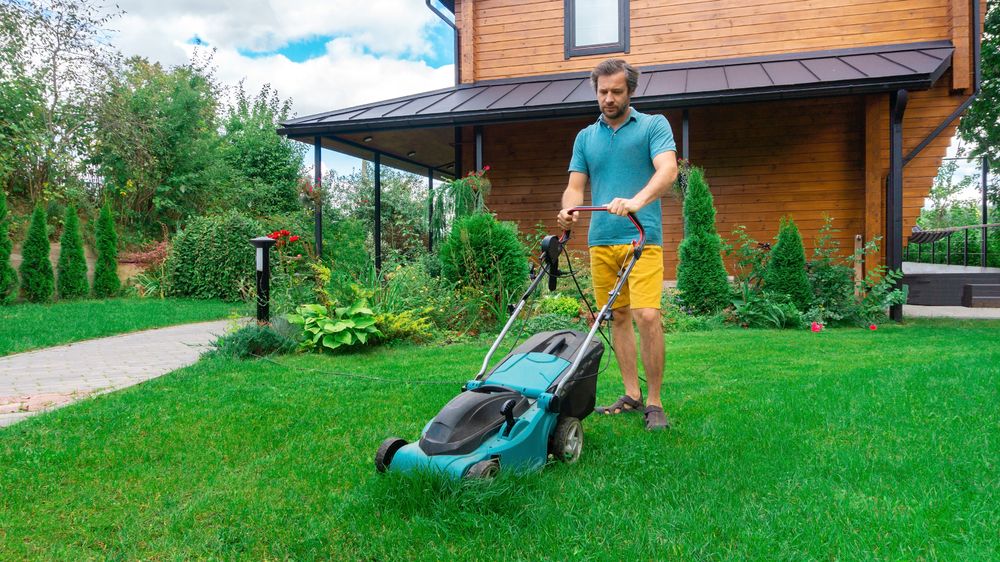 Man using an electric lawn mower
