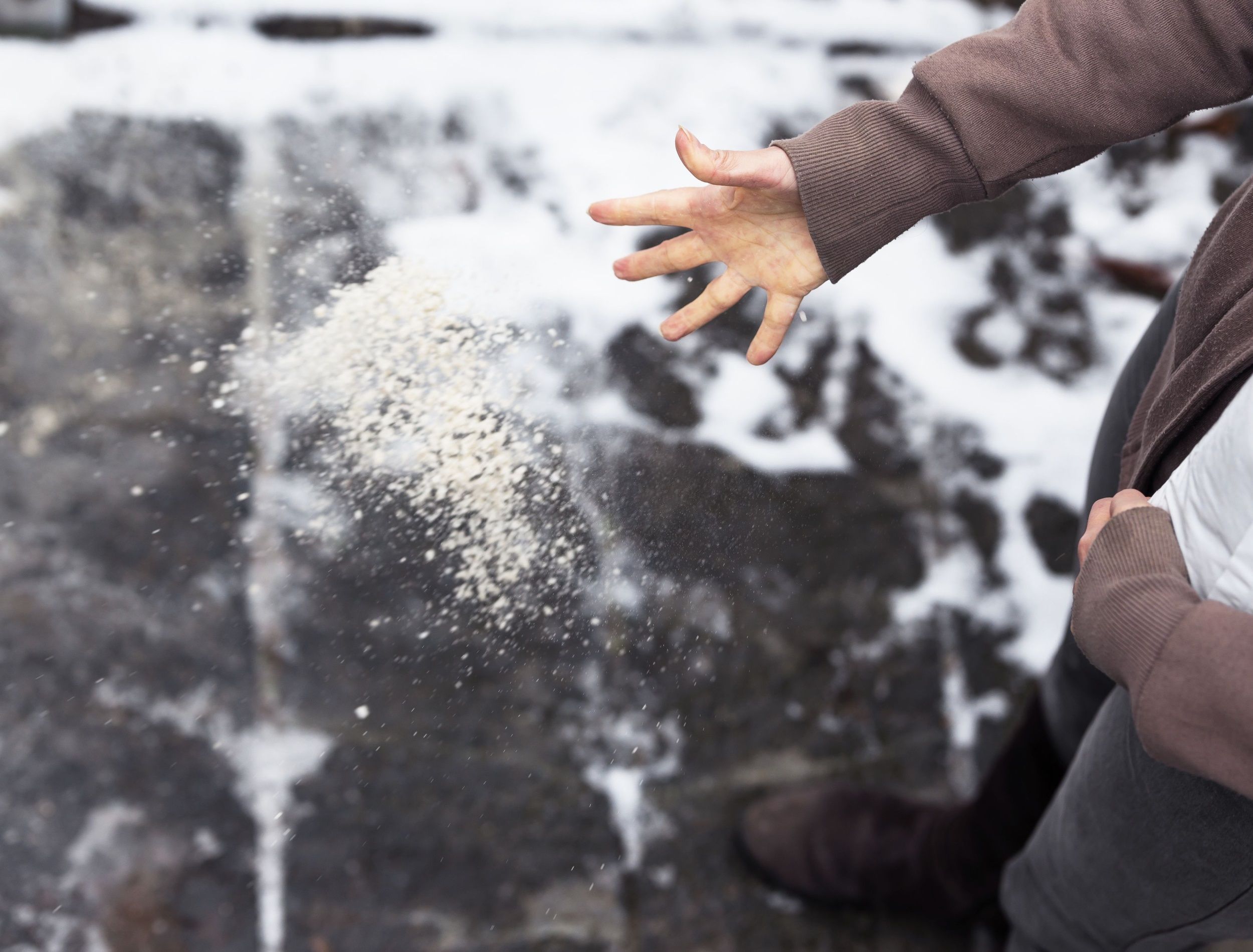 Woman descends her stairs in front of home with salt grit