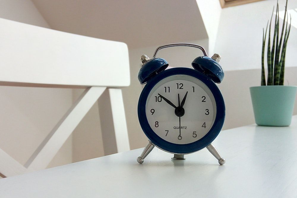 Clock and Plant on white table