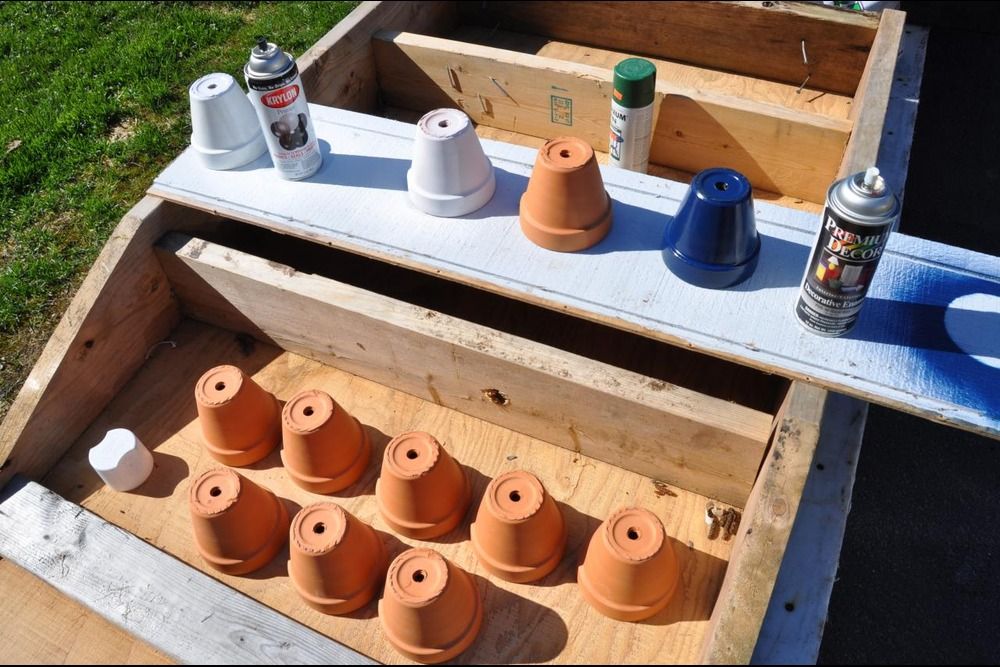 Terracotta pots lined up to be spray painted in different colours