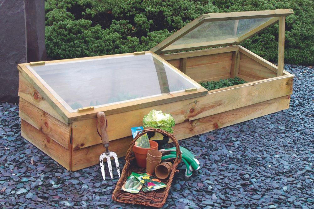 cold frame outdoors with gardening tools